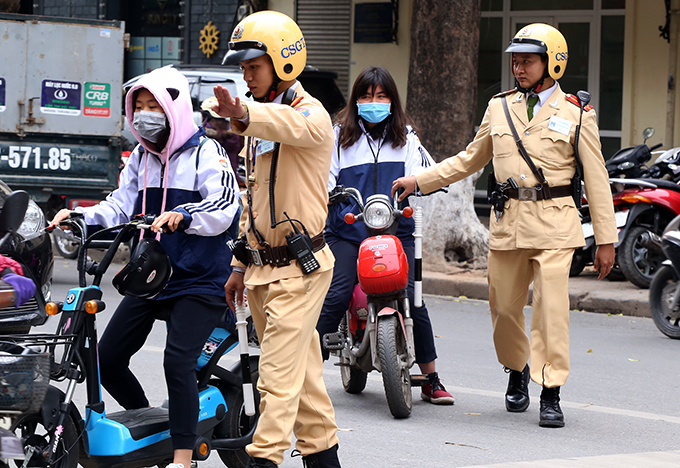 Cảnh sát giao thông Hà Nội trong một lần xử phạt người đi xe đạp điện vi phạm giao thông. Ảnh. Phương Sơn